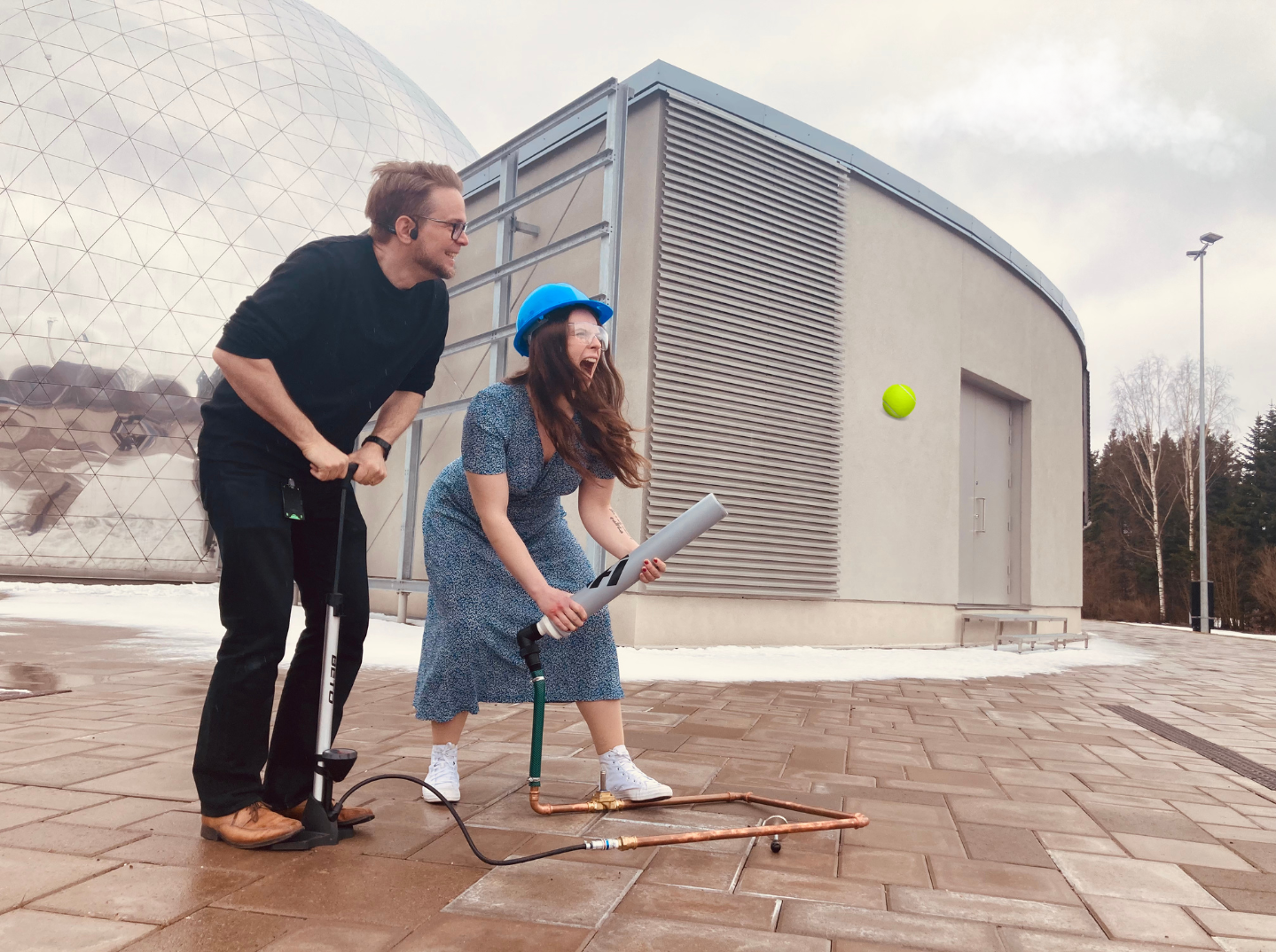 Tykkisankari-kuvassa mies ja nainen laukaisevat itse tehdyn tykin, josta lähtee tennispallo "kuulana".